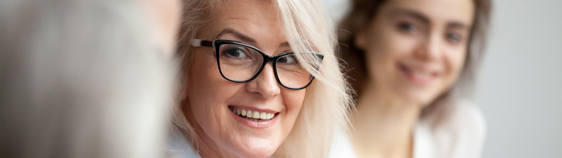 corp_news_header_image A woman with grey hair and glasses smiles.