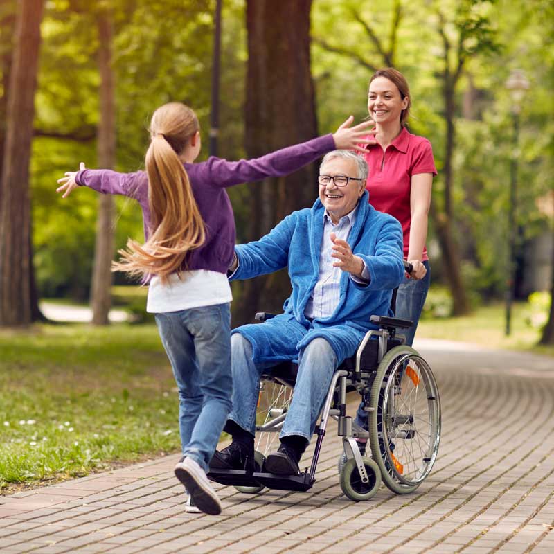 A senior man uses a wheelchair to enjoy the walking paths outside