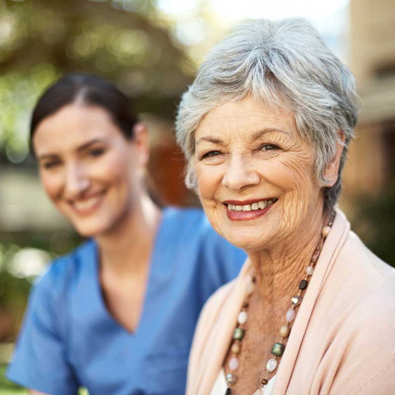 A senior woman and her health care professional pose for a photo